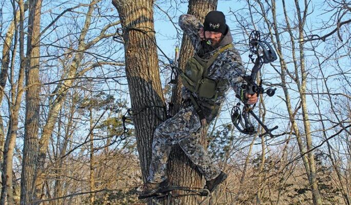 Bowhunter drawing compound bow from tree saddle