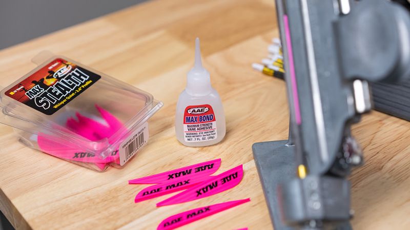 Arrow fletching vanes glue and jig components on workbench