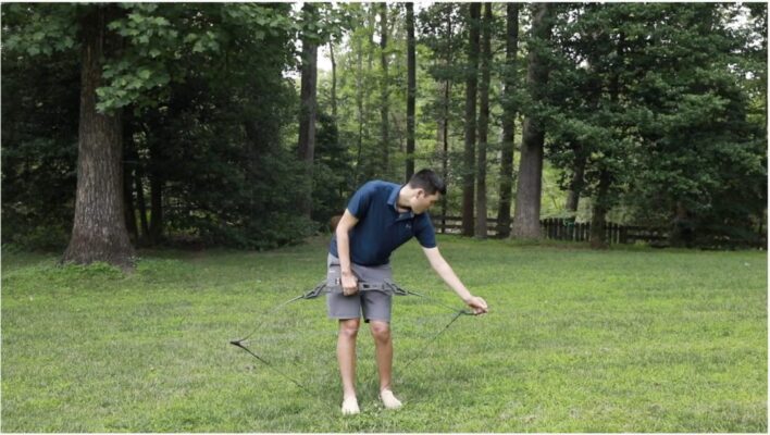 Archer using a bow stringer to string a recurve bow safely