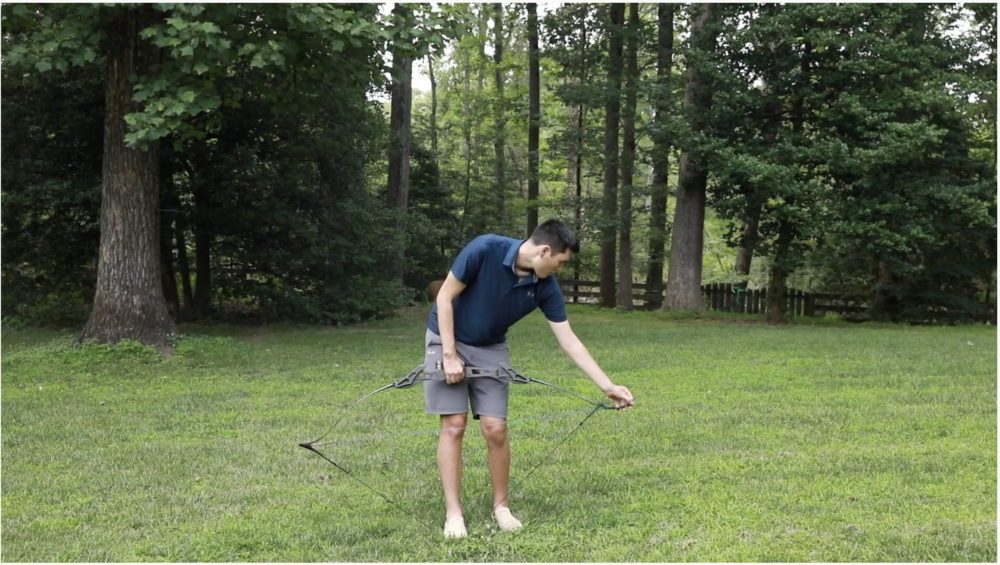 Archer using a bow stringer to string a recurve bow safely