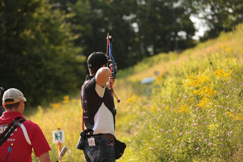 Archer at a numbered shooting stake on a 3D archery course