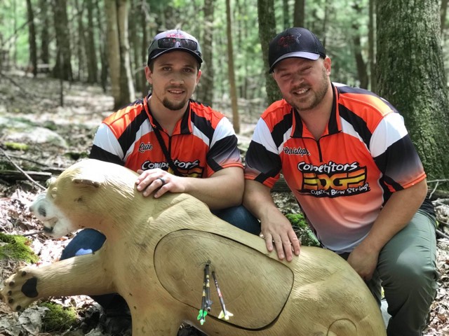 Two archers with foam bear 3D archery target in the woods