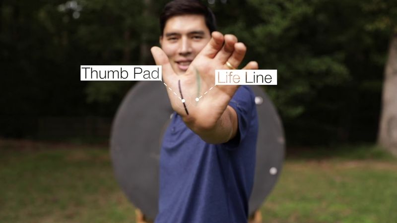 Close-up of an archer's bow hand grip on the riser showing correct hand placement