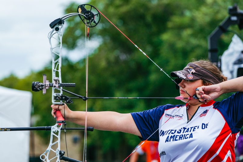 Archer at full draw during a coaching session at an archery range