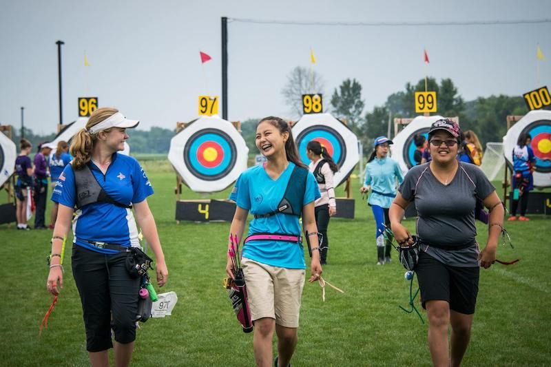 Archers practicing at an outdoor range in front of target faces
