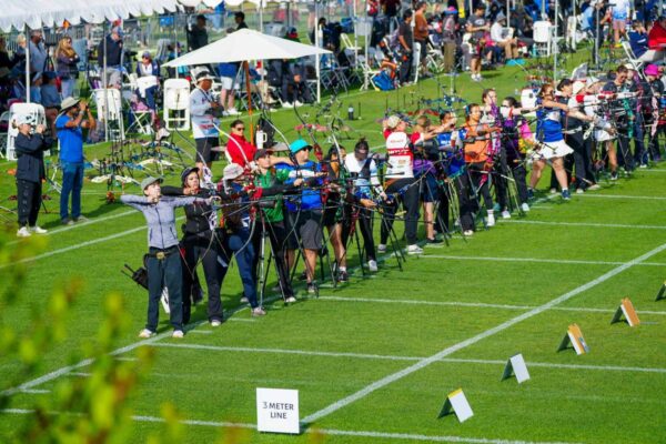 Archery ranges with a full line of archers shooting outdoors