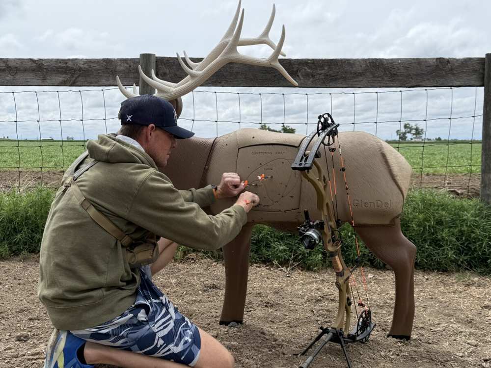 Bowhunter pulling arrows from a 3D elk target while tuning arrow spine