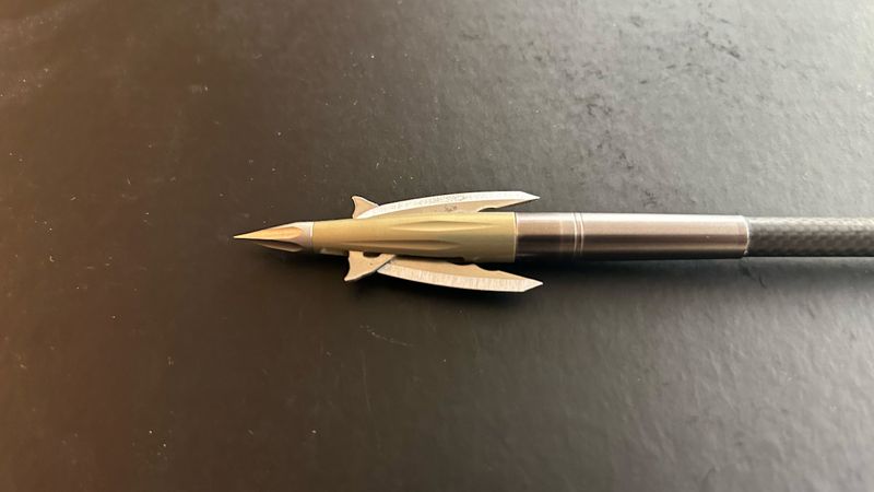 Beast mechanical broadhead with deployed blades on a carbon arrow