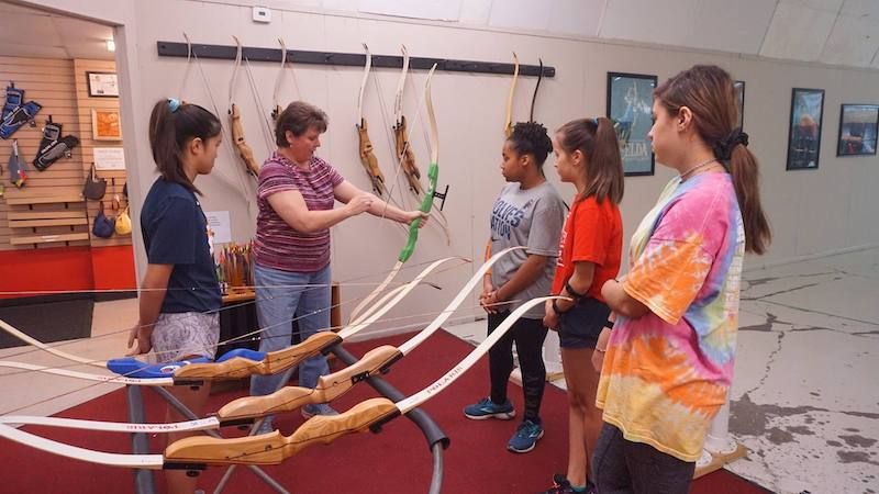 Beginners learning beginner draw weight in an archery class with light recurve bows