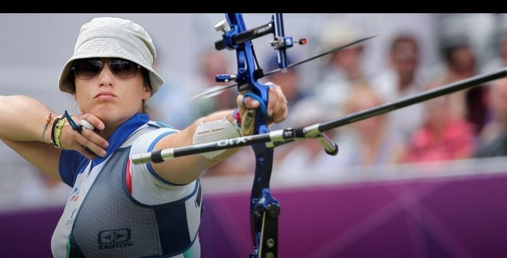 Olympic recurve archer at full draw with low-stretch bowstring material