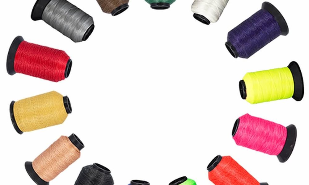 Spools of bowstring material strands in multiple colors for building strings