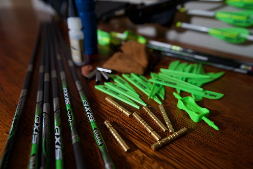 Carbon arrow shafts laid out with inserts, points and vanes for arrow spine matching