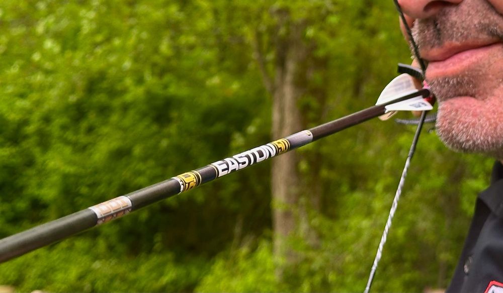 Close-up of a carbon arrow shaft flexing at full draw showing dynamic arrow spine
