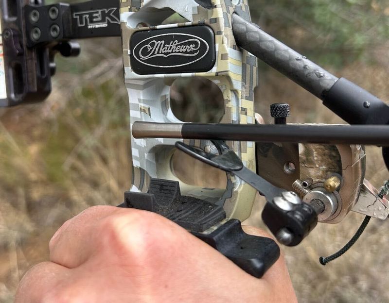 Compound bow riser and arrow rest close-up during broadhead tuning setup