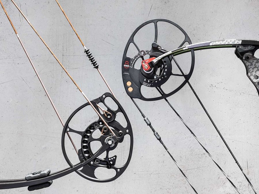 Close-up of a compound bow's cams and pulley system with cables and string