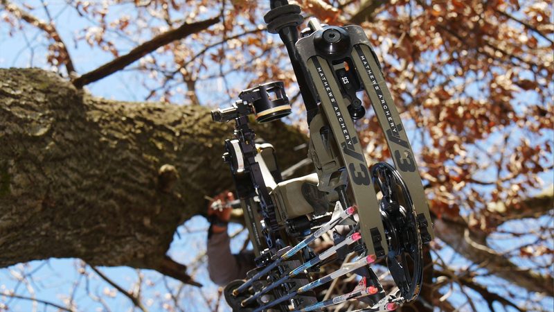 Compound bow with sight and stabilizer mounted in a treestand