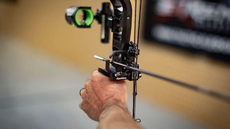 drop away arrow rest mounted on compound bow with arrow nocked showing launcher mechanism