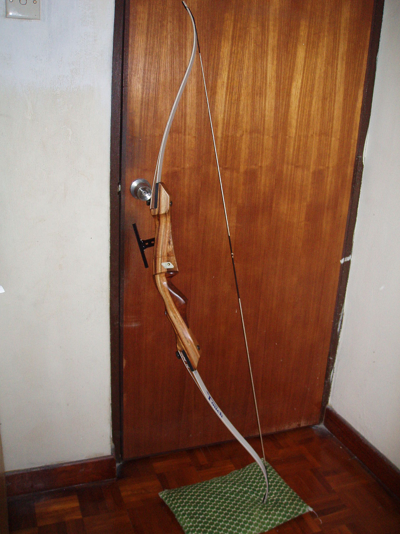 Wooden takedown recurve bow showing the curved limb tips that define a recurve