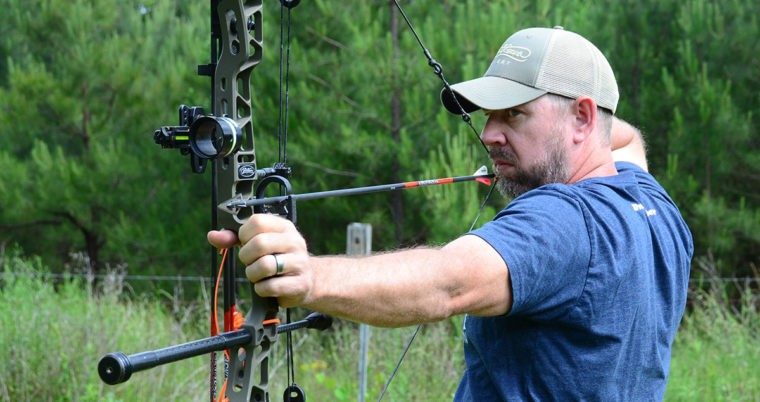 Bowhunter at full draw testing a hunting arrow weight setup