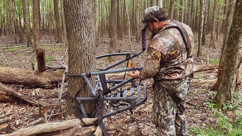 Hunter assembling hang-on tree stand before climbing