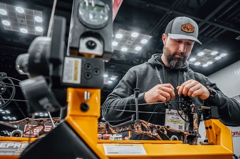 Technician tuning a new 2026 compound bow at the ATA Show