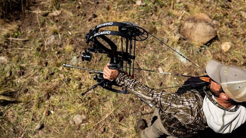 Hunter using the PSE Sicario Carbon FDS 357 fps compound bow in a field hunting setting