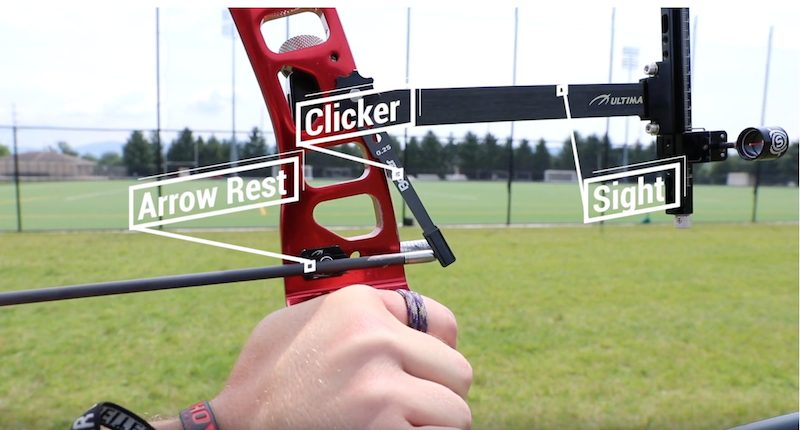 Close-up of a recurve bow riser showing arrow rest, clicker and string groove