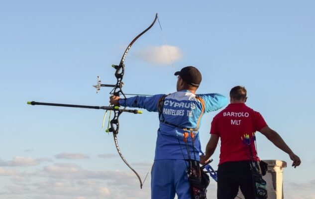 Recurve archers at full draw using an archery clicker to check draw length