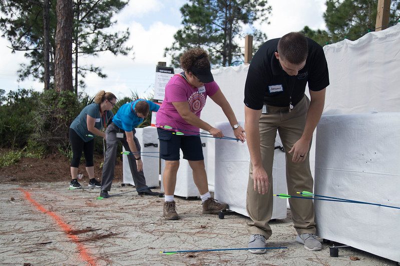 Archers retrieving arrows from a target at an outdoor range