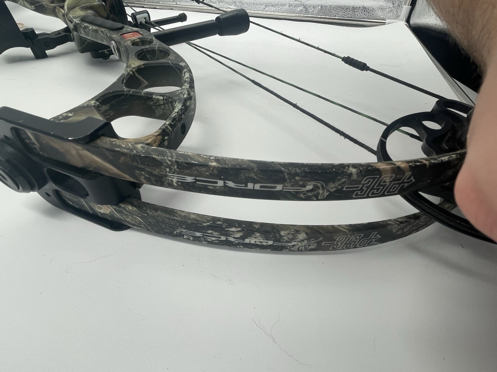 Camouflaged PSE x-force pro series compound bow with black accents and visible “FORCE” and “355” branding on the limbs.