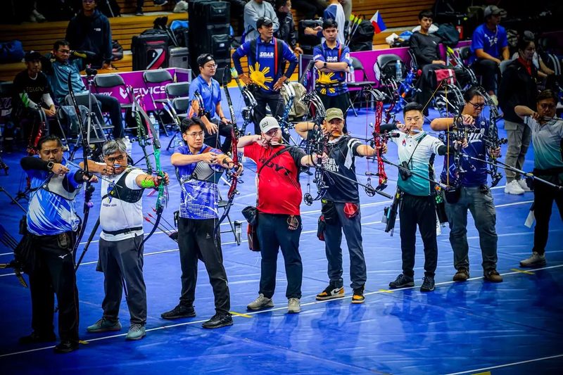 Archers on the shooting line during indoor archery competition