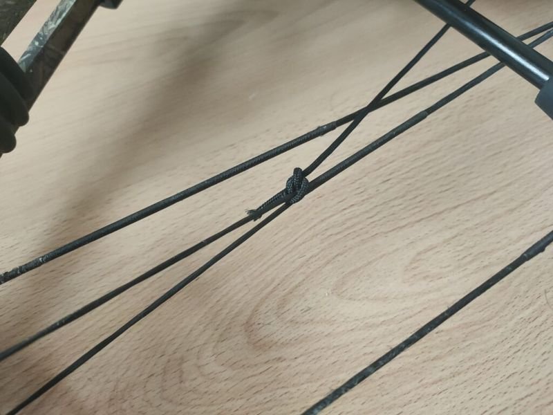 arrow rest timing cord tied with lark's head knot on compound bow cable