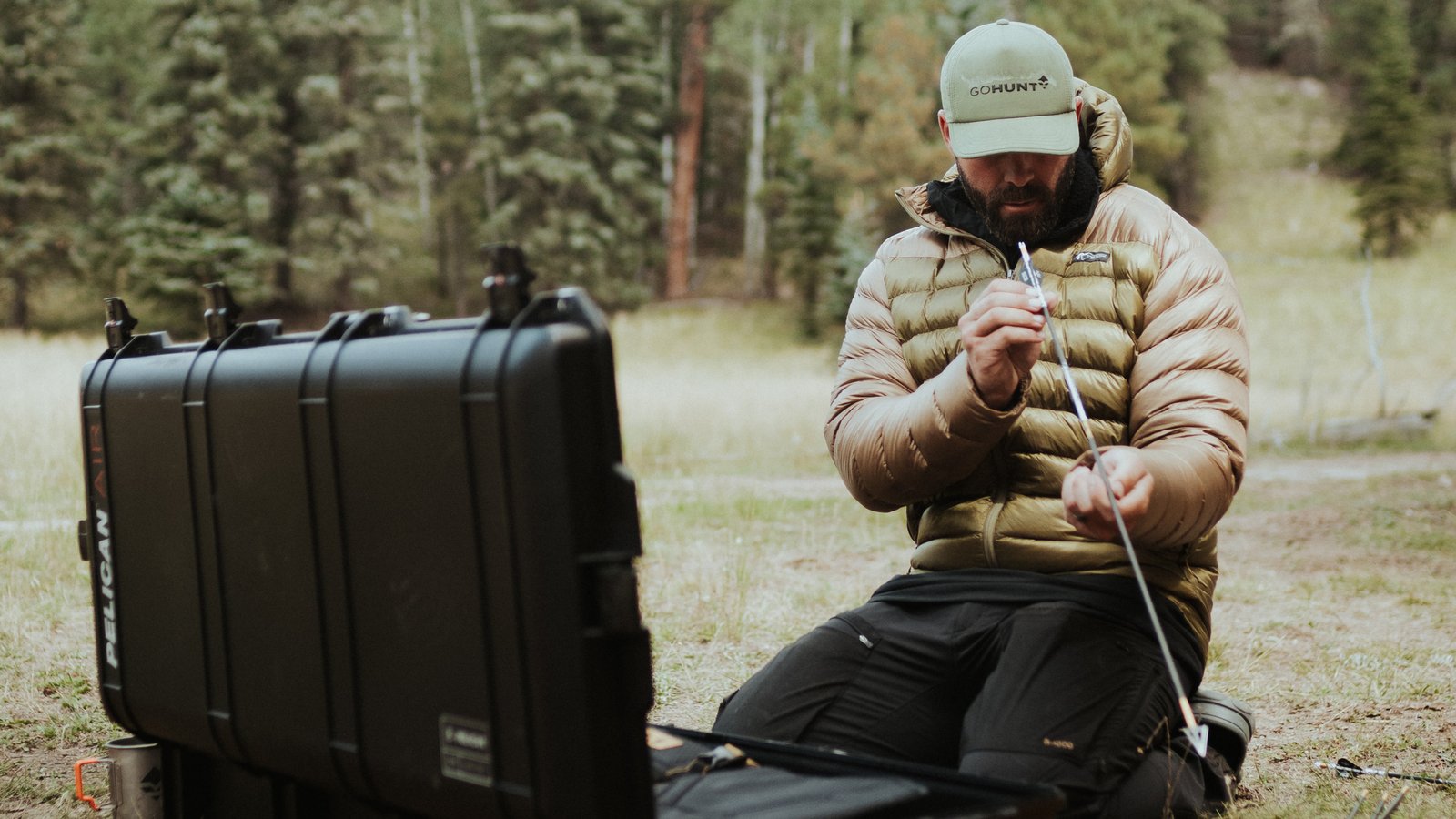 bowhunter installing broadhead onto arrow shaft before hunt