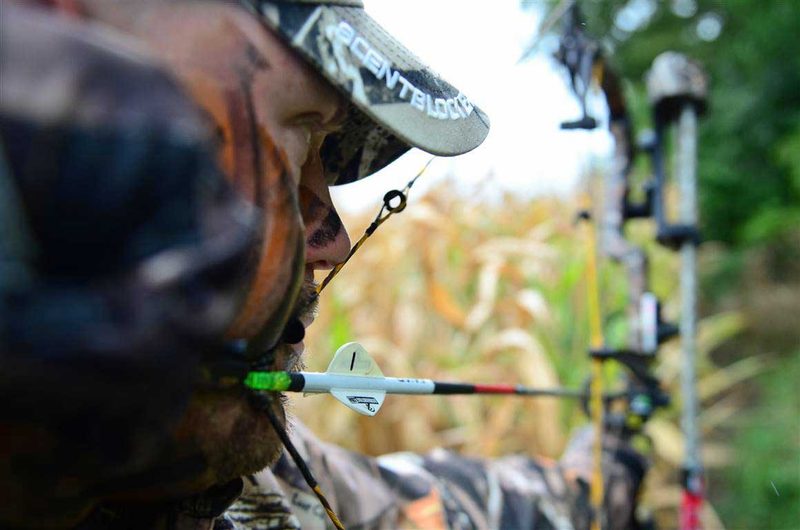 Bowhunter at anchor looking through compound bow peep sight for accurate shot
