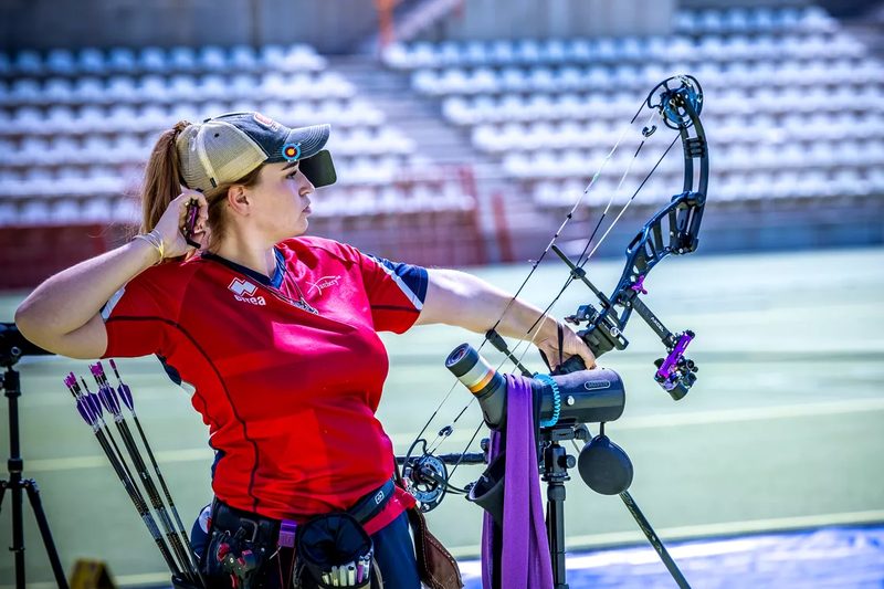 Compound archer demonstrating breathing technique and back tension at full draw indoors