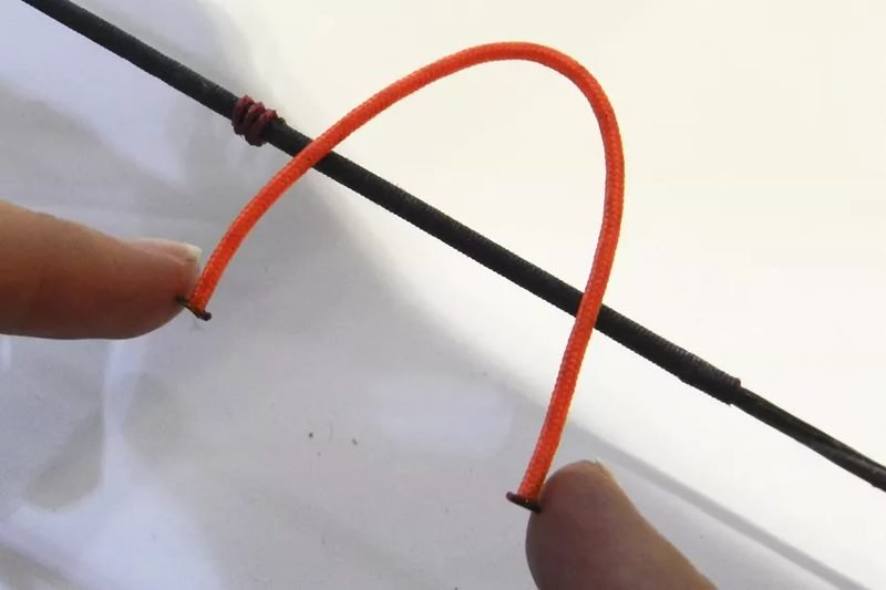D-loop cord threaded through compound bow string