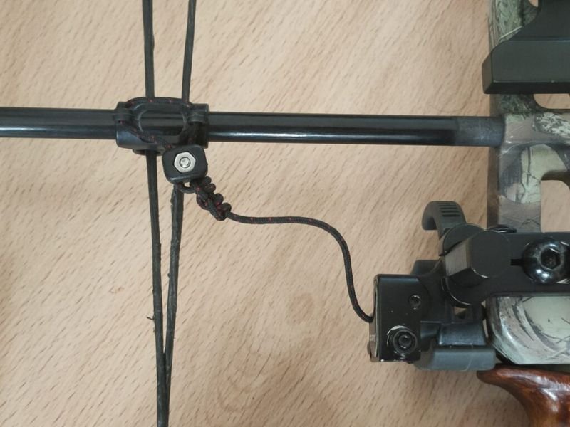 drop-away arrow rest activation cord tied to compound bow cable slide