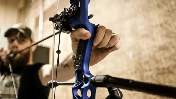 An archer drawing a compound bow with drop-away arrow rest installed for setup and tuning