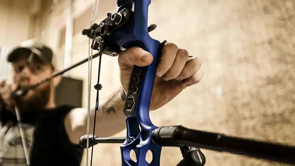 An archer drawing a compound bow with drop-away arrow rest installed for setup and tuning
