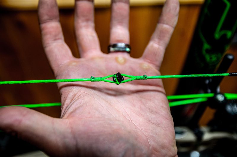 Close-up of peep sight tied and served into compound bow bowstring