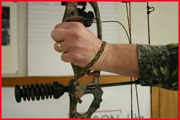 Bow wrist sling in use during compound bow shooting at archery range